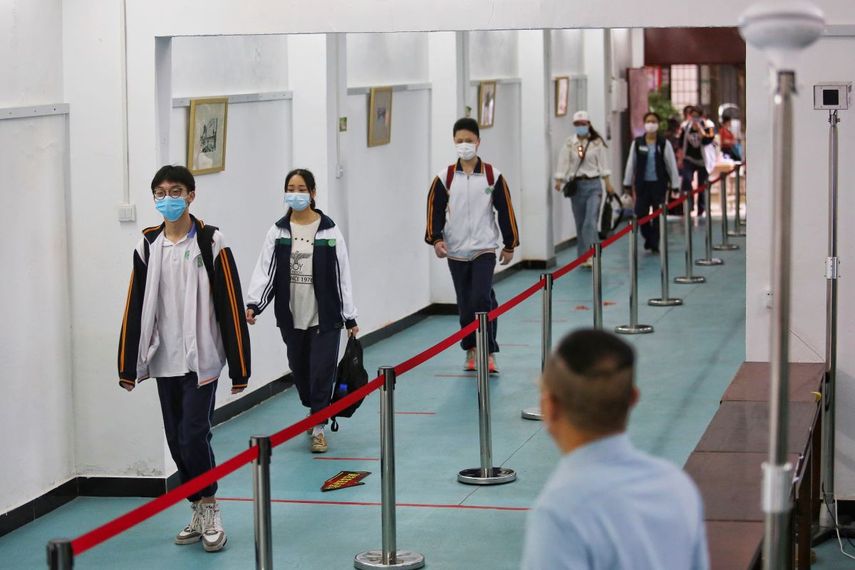 Estudiantes con mascarillas y a cierta distancia unos de otros para evitar la propagación del coronavirus llegan a una secundaria el miércoles 6 de mayo de 2020 en la ciudad de Wuhan, provincia de Hubei, en el centro de China.&nbsp;