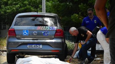 Agentes de la policía civil de Ceará revisan los cuerpos de dos adolescentes muertos en un tiroteo dentro del estacionamiento de una escuela pública en Sobral, estado de Ceará, Brasil, el 25 de septiembre de 2025.