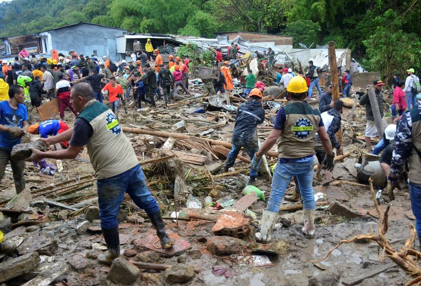 Vecinos y equipos de rescate buscan sobrevivientes donde una ladera debilitada por la lluvia se derrumbó sobre las casas de las personas en Pereira, Colombia, el martes 8 de febrero de 2022.
