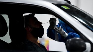 Un trabajador de salud recolecta muestras para la prueba de detección de casos de coronavirus COVID-19 dentro de un automóvil, en el centro de convenciones Costa Salguero, en Buenos Aires, el 5 de abril de 2021. El centro de convenciones se convirtió en un centro de pruebas de COVID para personas después de regresar de vacaciones. Argentina, con una población de 45,4 millones, tiene casi 2,4 millones de casos de covid-19, con más de 56.000 muertes.&nbsp;