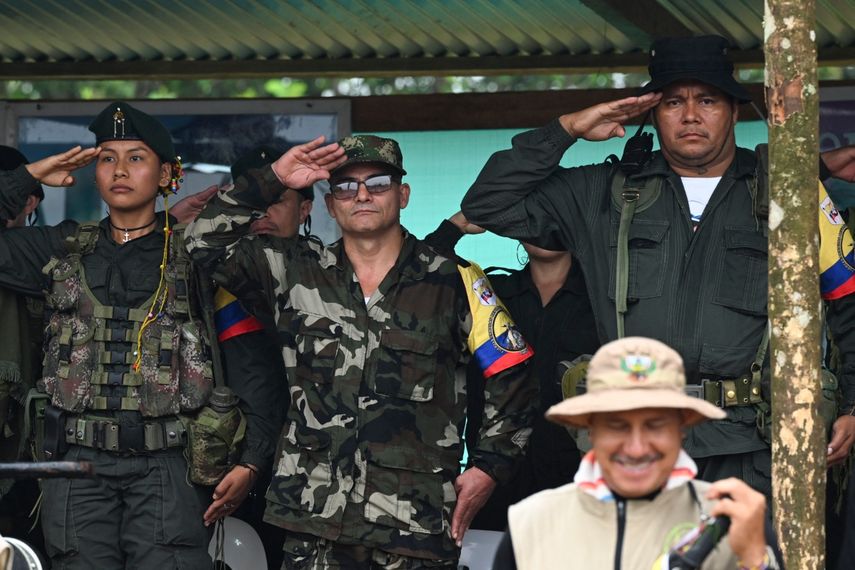 El máximo comandante de la disidencia de las FARC EP, alias Iván Mordisco (C), saluda a los militares junto al comandante Calarcá (R) durante una reunión con comunidades locales en San Vicente del Caguán, departamento de Caquetá, Colombia, el 16 de abril de 2023.