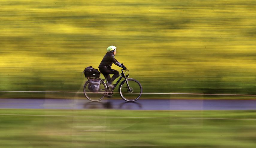 En esta foto del 18 de abril del 2017, una mujer pasa en su bicicleta junto a un campo de colza en Fráncfort, Alemania.&nbsp;