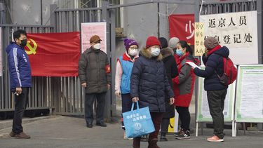 Residentes esperan para entrar a un &aacute;ea que dice punto de registro para personas que regresan a Beijing, en Beijing, China, el jueves 13 de febrero de 2020.