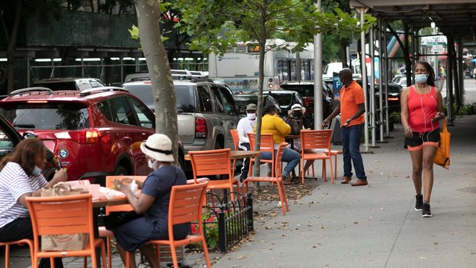 Gente come en las mesas de acera del restaurante Juniors, Nueva York, 30 de junio de 2020. El alcalde Bill de Blasio dijo el mi&eacute;rcoles 1 de julio de 2020 que se demora la reapertura de los recintos interiores de los restaurantes para prevenir un nuevo foco de contagio del coronavirus.&nbsp;