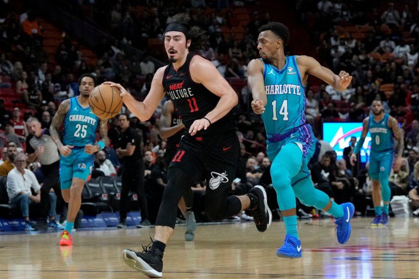 El armador mexicano del Heat de Miami, Jaime Jaquez Jr. (11), conduce hacia el aro mientras defiende el base de los Hornets de Charlotte, Ish Smith (14), durante la primera mitad del juego de baloncesto de la NBA, el domingo 14 de enero de 2024, en Miami.&nbsp;