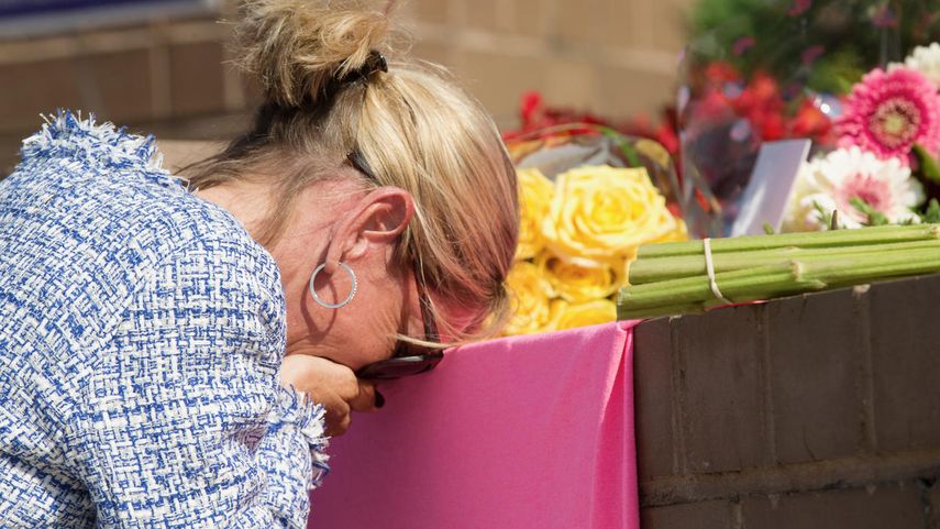 &nbsp;Un doliente no identificado llora en un pequeño monumento en la entrada de 888 Bestgate Road el viernes 29 de junio de 2018.&nbsp;&nbsp;&nbsp;