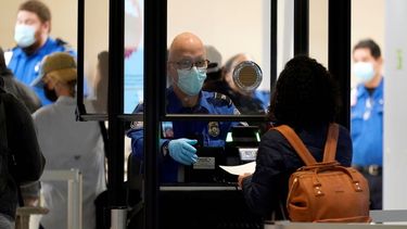 Un agente de la TSA le pide la documentación a una persona.