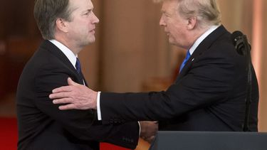 El presidente Donald Trump (der.) saluda al juez Brett Kavanaugh tras presentar su nominación al Tribunal Supremo el 9 de julio de 2018.