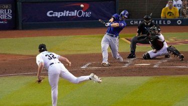 Corey Seager, centro, de los Rangers de Texas, batea un cuadrangular de dos carreras frente al abridor de los Cascabeles de Arizona, Brandon Pfaadt (32), durante la tercera entrada del Juego 3 de la Serie Mundial, el lunes 30 de octubre de 2023, en Phoenix.&nbsp;