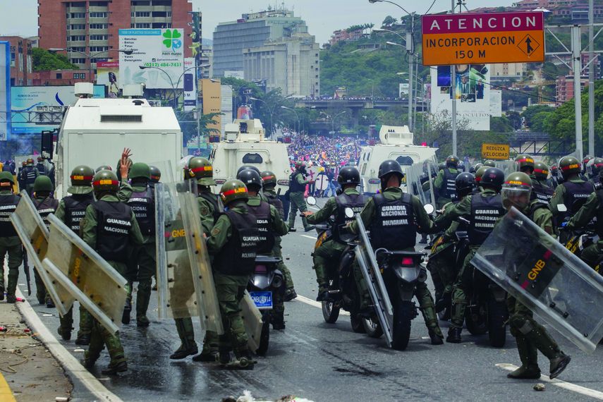 Miembros de la Guardia Nacional dispersan con gases lacrimógenos una movilización opositora en el este de Caracas.
