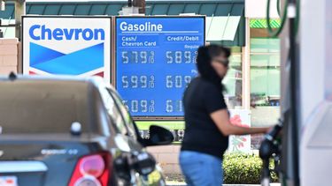 Una mujer echa gasolina a su auto en junio de 2022, con precios por encima de los 5 dólares el galón regular.