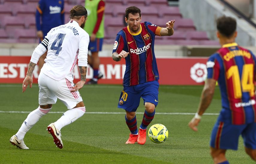 El delantero argentino Lionel Messi disputa el balón con Sergio Ramos del Real Madrid en el partido por La Liga de España, el sábado 24 de octubre de 2020.&nbsp;