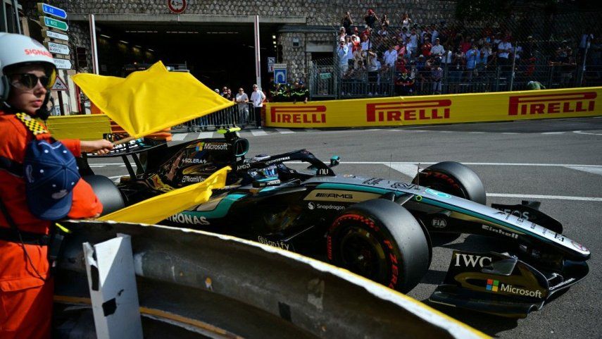 Un miembro del personal del circuito ondea banderas amarillas mientras el piloto italiano de Mercedes, Kimi Antonelli, finaliza su participación en la sesión de clasificación en el circuito urbano de Mónaco, de cara al Gran Premio de Fórmula 1 de Mónaco, que se celebrará el 6 de junio de 2026.