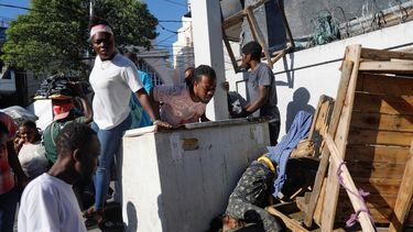 Un grupo de personas observa un cadáver tras un tiroteo durante la noche en el vecindario Petion Ville de Puerto Príncipe, Haití, el 18 de marzo de 2024.&nbsp;