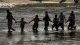 Migrantes forman una cadena humana para cruzar el Río Bravo desde México a Estados Unidos, el 21 de septiembre de 2023, en Eagle Pass, Texas.&nbsp; 