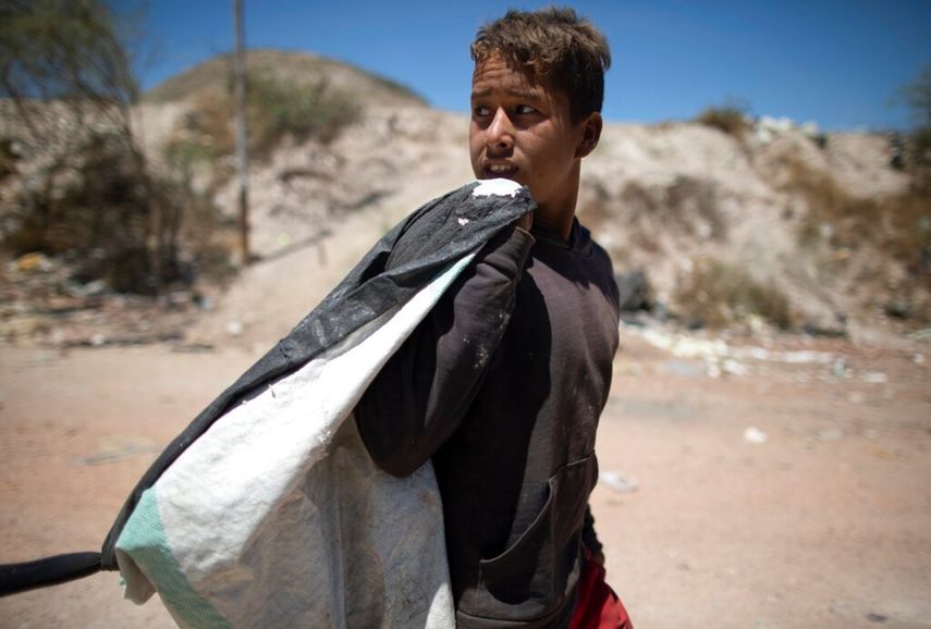 Ronaikel Brito camina a casa con un saco de cosas que recogió del basurero de Pavia que puede vender, en las afueras de Barquisimeto, Venezuela.