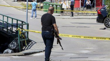 Un policía vestido de civil sostiene un rifle durante un operativo para capturar a un hombre que mató a su exesposa y lo transmitió en vivo por Instagram, en Gradacac, Bosnia, el 11 de agosto de 2023 .
