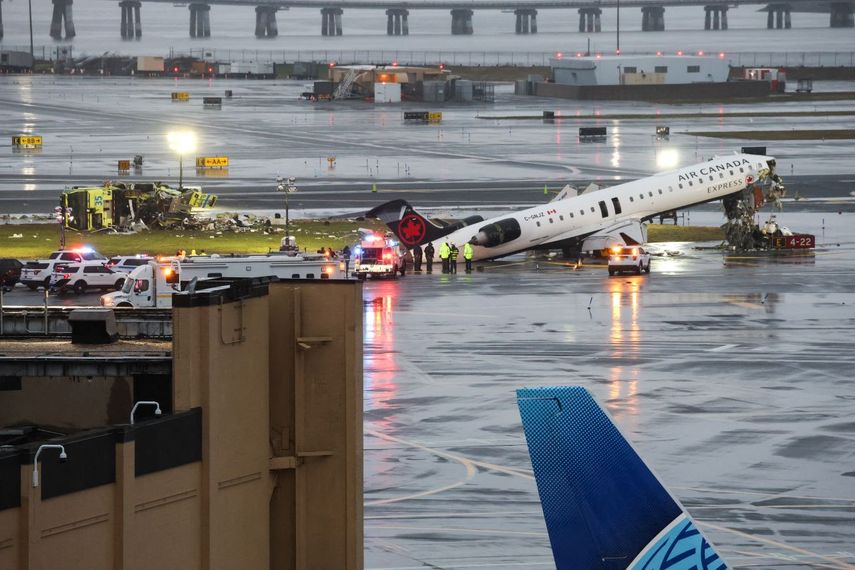 Un CRJ-900 de Air Canada Express se encuentra en la pista después de chocar con un camión de bomberos de la Autoridad Portuaria (L) en el Aeropuerto LaGuardia en Nueva York, el 23 de marzo de 2026.