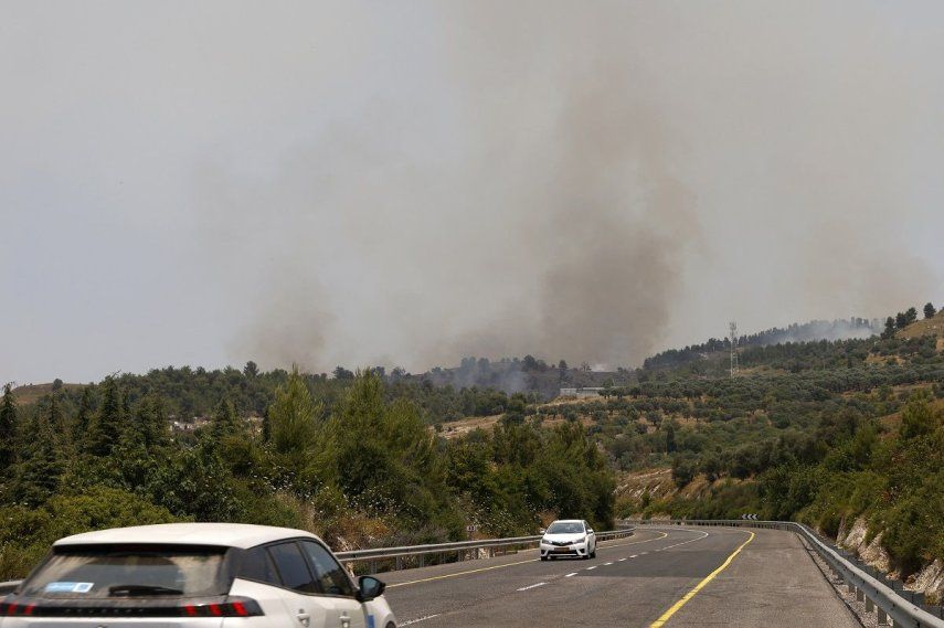 Los automóviles circulan por una carretera mientras los incendios queman la vegetación después de que cohetes lanzados desde el sur del Líbano aterrizaran en las afueras de Safed, en la alta Galilea de Israel, el 12 de junio de 2024.&nbsp;