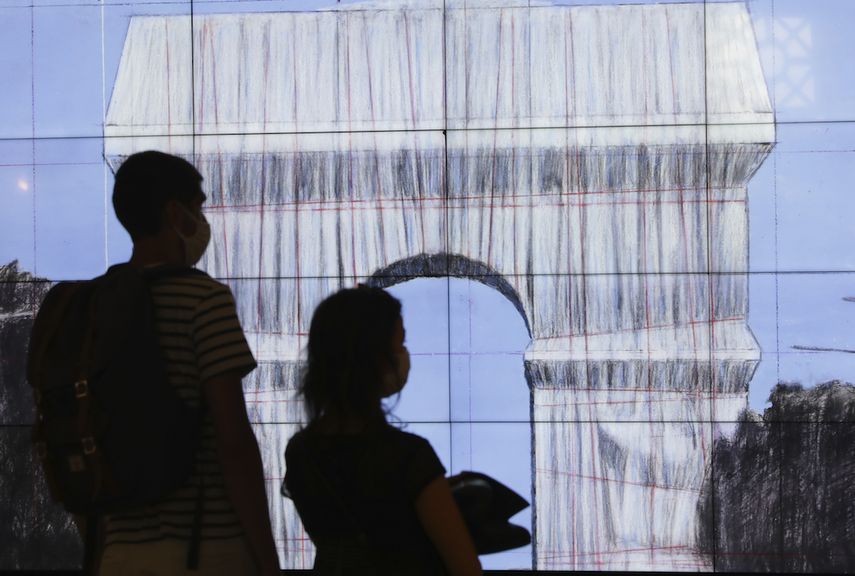 Visitantes ven un video sobre la instalación LArc de Triomphe, Wrapped en París, que ocurrirá el próximo mes como parte de un montaje artístico póstumo diseñado por los artistas Christo y Jeanne-Claude.