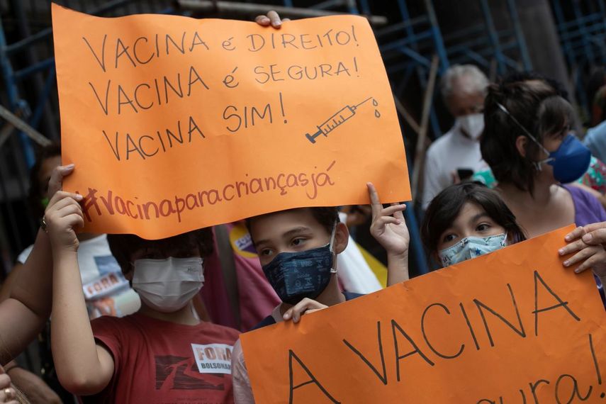 Niños sostienen letreros con el mensaje en portugués: “¡La vacuna es un derecho! ¡La vacuna es segura! ¡Sí a la vacuna!”, durante una manifestación a favor de la vacuna contra el COVID-19 en Río de Janeiro, el miércoles 5 de enero de 2022. (AP Foto/Bruna Prado)