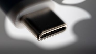 Esta fotografía tomada el 14 de septiembre de 2023 muestra un enchufe USB-C reflejado en el logotipo de Apple en Brest, oeste de Francia.