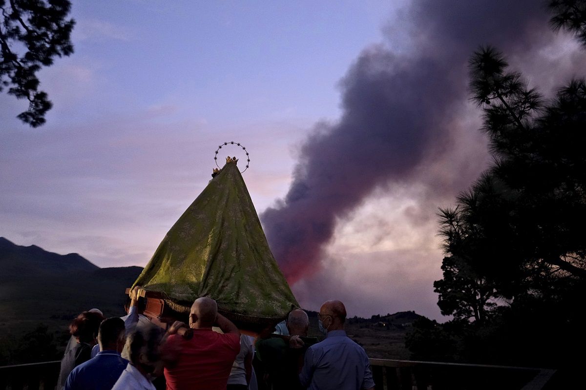 Varios fieles católicos cargan una imagen de la Virgen de El Pino durante una procesión con la que buscan detener la actividad volcánica en la isla canaria de La Palma, España, el martes 19 de octubre de 2021. Varios fieles católicos cargan una imagen de la Virgen de El Pino durante una procesión con la que buscan detener la actividad volcánica en la isla canaria de La Palma, España, el martes 19 de octubre de 2021.