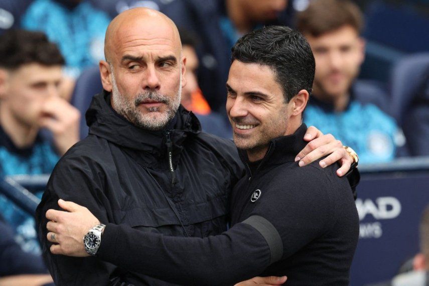El técnico español del Manchester City, Pep Guardiola (izquierda), abraza al técnico español del Arsenal, Mikel Arteta, antes del inicio del partido de la Premier League inglesa entre el Manchester City y el Arsena