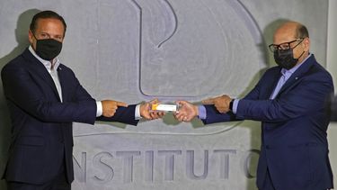 El gobernador del estado de Sao Paulo João Doria, izquierda, y el director del Instituto Butantan, Dimas Covas, sostienen una caja de una vacuna experimental contra el COVID-19 que está siendo sometida a pruebas en sociedad con la farmacéutica china Sinovac, durante una conferencia de prensa el lunes 9 de noviembre de 2020, en Sao Paulo, Brasil.
