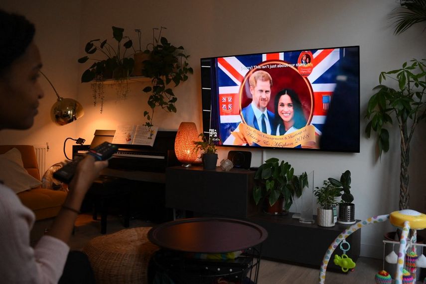 Una mujer posa mientras mira un episodio de la serie documental de Netflix recientemente lanzada Harry y Meghan sobre el príncipe Harry de Gran Bretaña, duque de Sussex, y Meghan de Gran Bretaña, duquesa de Sussex, en Londres el 8 de diciembre de 2022. 