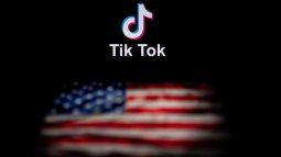 La foto muestra el logotipo de la aplicación de red social TikTok (arriba) y una bandera de Estados Unidos (abajo) en las pantallas de dos computadoras.