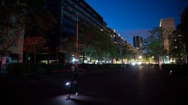 Un peatón utiliza una linterna para caminar por una calle de Barcelona, sin electricidad, tras un apagón masivo que afectó a toda la península Ibérica y al sur de Francia, el 28 de abril de 2025.