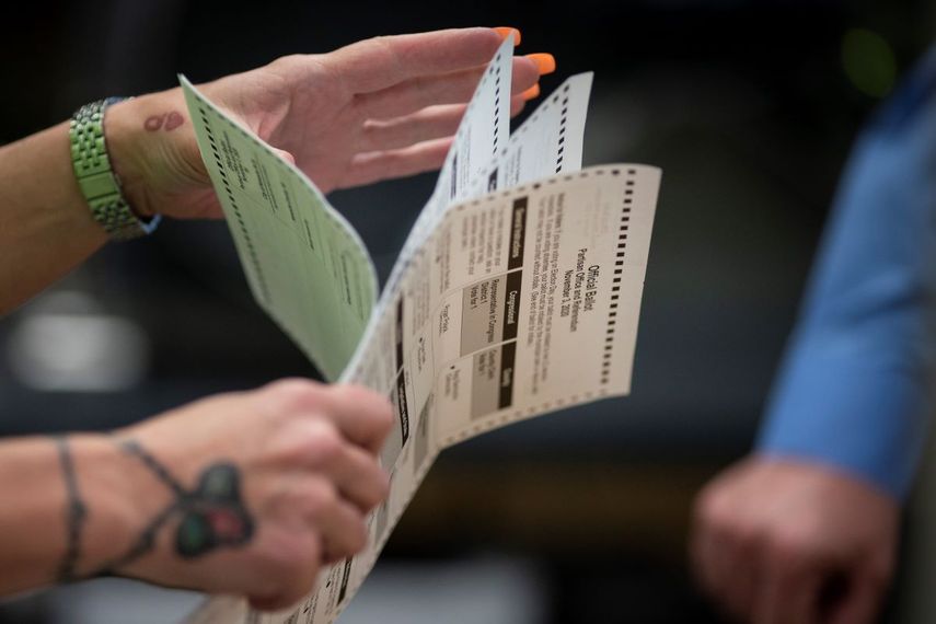 Una empleada electoral revisa boletas.