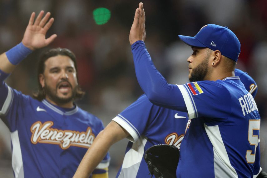 Eduardo Rodríguez #52 de la selección de Venezuela choca las cinco con Eugenio Suárez #7 mientras este abandona el campo tras ser retirado del partido contra la selección de Estados Unidos