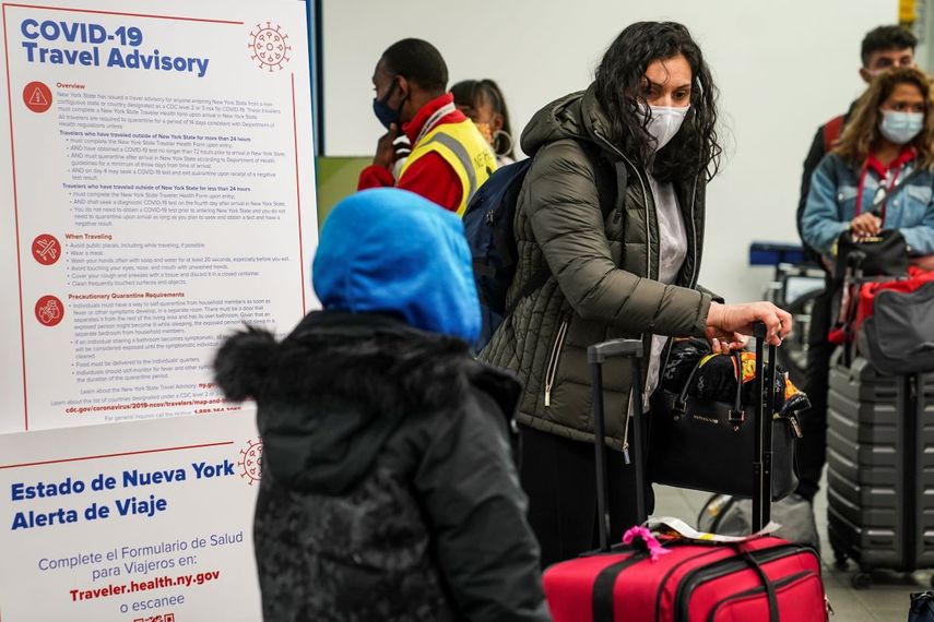 Varias personas portan mascarillas para evitar la propagación del COVID-19 mientras se preparan para abandonar la zona de entrega de equipaje en el Aeropuerto LaGuardia, el miércoles 25 de noviembre de 2020, en Nueva York.&nbsp;