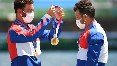 El medallista de oro de Cuba Serguey Torres Madrigal (der.) recibe la medalla de manos de su compañero de equipo Fernando Dayan Jorge Enríquez durante los Juegos Olímpicos de Tokio 2020