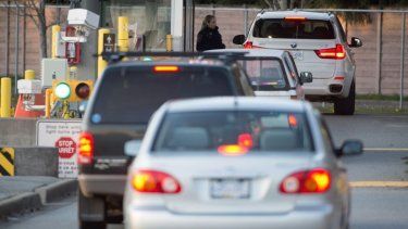Un oficial de la Agencia de Servicios Fronterizos de Canadá inspecciona un vehículo que ingresa a territorio canadiense en el cruce fronterizo Peace Arch, en Surrey, Columbia Británica.&nbsp;