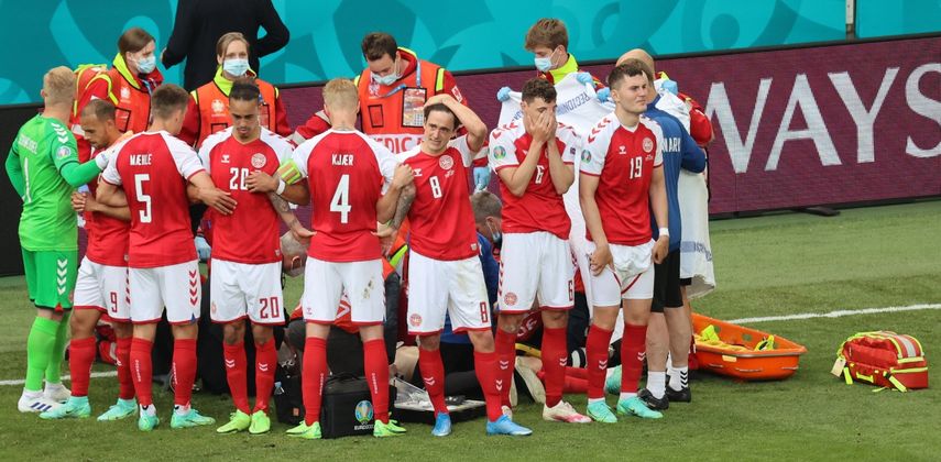 Los jugadores de Dinamarca se reúnen mientras los paramédicos atienden al mediocampista Christian Eriksen (no visto) durante el partido de fútbol del Grupo B de Eurocopa 2020 entre Dinamarca y Finlandia en&nbsp; Copenhague el 12 de junio de 2021