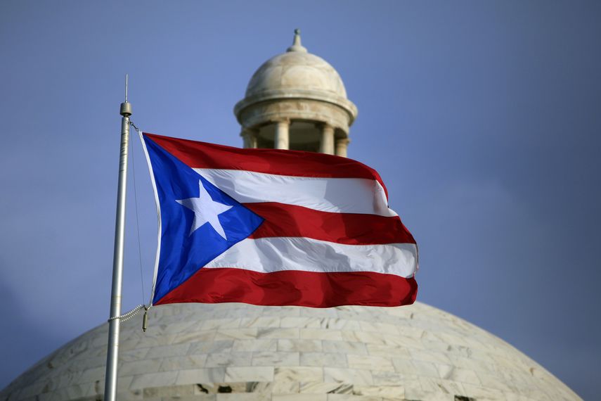 En esta imagen del 29 de julio de 2015, una bandera de Puerto Rico ondea frente al Capitolio de la isla, en San Juan.&nbsp;