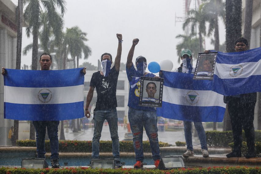 Los manifestantes sostienen banderas nacionales de Nicaragua y fotos de estudiantes asesinados durante una marcha antigubernamental denominada Nada es normal en honor a Matt Romero, en Managua, Nicaragua, el sábado 21 de septiembre de 2019.