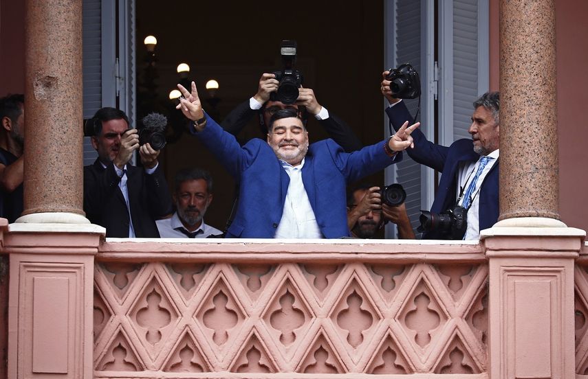 El futbolista Diego Maradona hace se&ntilde;ales de victoria a los fan&aacute;ticos en la casa del gobierno despu&eacute;s de reunirse con el presidente argentino Alberto Fern&aacute;ndez en Buenos Aires, Argentina, el jueves 26 de diciembre de 2019.&nbsp;