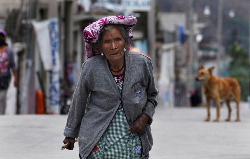 Una mujer camina sobre las calles cubiertas con la ceniza del volcán Popocatépetl, el lunes 22 de mayo de 2023, en Santiago Xalitzintla, México. 