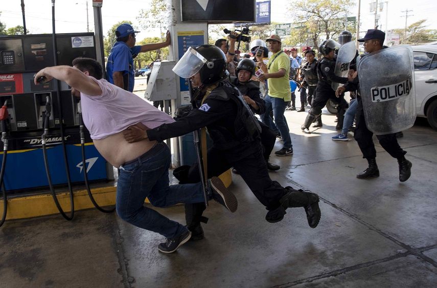 Miembros de la Policía Nacional intentan detener al reportero gráfico Luis Sequeira, de la agencia AFP, durante una manifestación contra el régimen de Daniel Ortega este 16 de marzo de 2019, en Managua, Nicaragua.