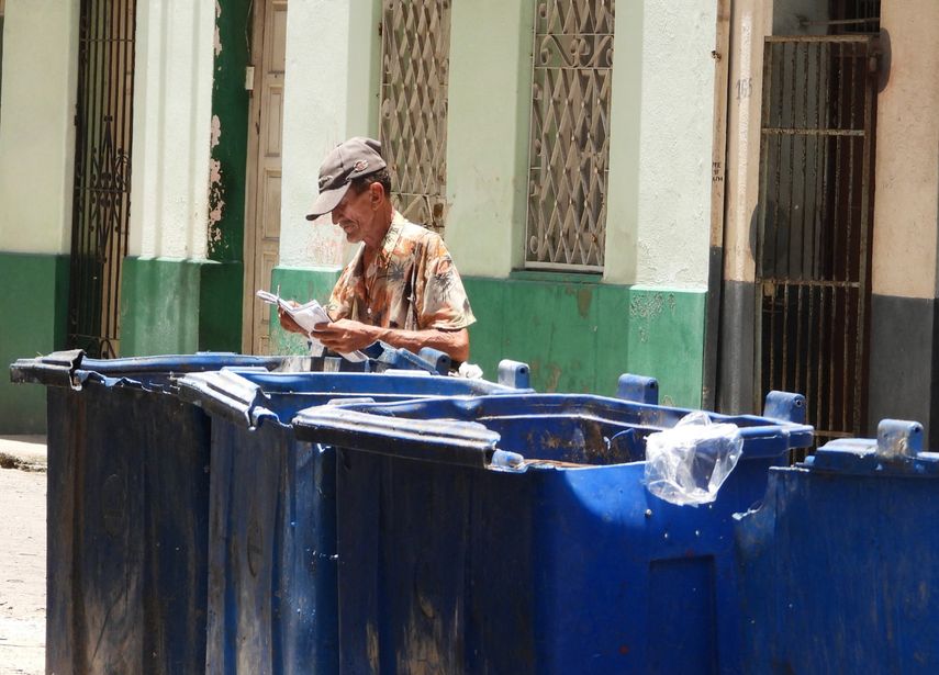 Un hombre busca en la basura en Cuba.