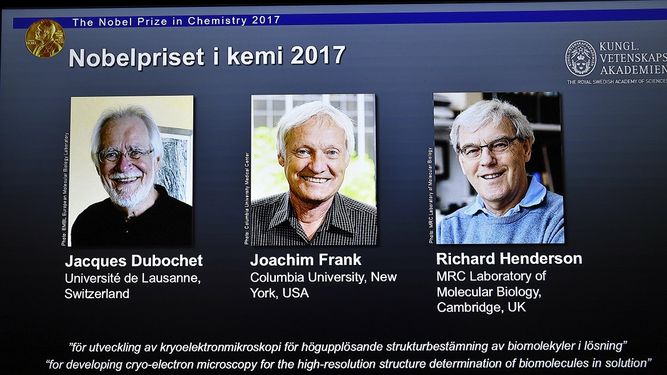 Una pantalla muestra a los tres ganadores del Premio&nbsp;Nobel&nbsp;de Química 2017 por desarrollar la criomicroscopía electrónica para la determinación estructural en alta resolución de biomoléculas en soluciones: