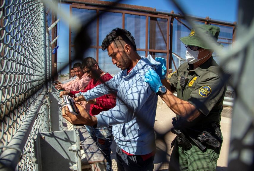 A Border Patrol agent checks migrants as they enter El Paso, Texas, from Ciudad Juarez, Mexico, on Wednesday, May 10, 2023.