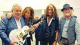 Integrantes de la banda de rock junto al presidente de Uruguay. (EFE)
