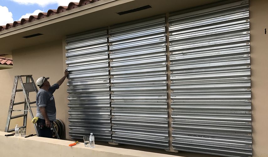 Un hombre protege las ventanas de su vivienda en Miami, ante la cercanía de un huracán.