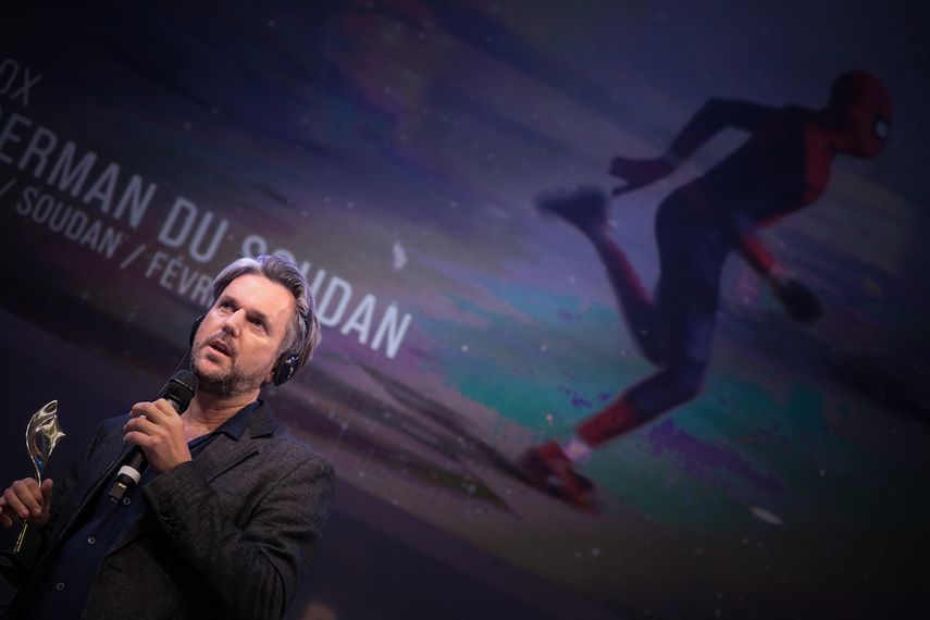 El periodista británico Philip Cox se dirige a los presentes luego de recibir el premio Bayeux por su proyecto The Spider-Man of Sudan.