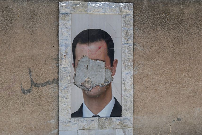Un retrato desfigurado del derrocado presidente sirio, Bashar al-Assad, cuelga en una pared de la capital, Damasco, el 2 de junio de 2025.